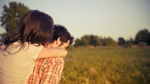 Husband and Wife Embrace in a Field