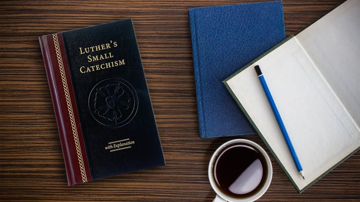 Luther's Small Catechism on desk with books and pencil