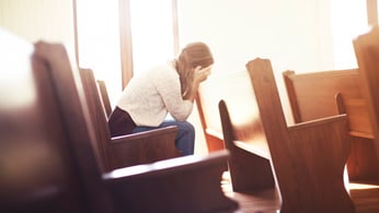 Woman Sitting in Church Pews