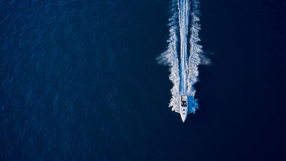 A boat speeding over the open ocean. 