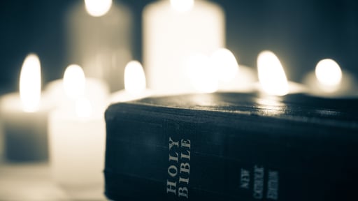 Bible in front of lit candles