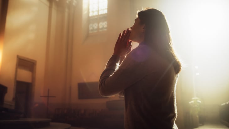 Woman praying in church sanctuary