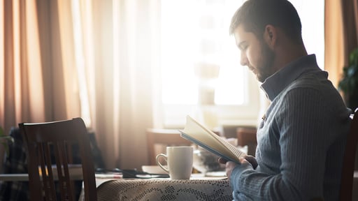 Man reads book at table