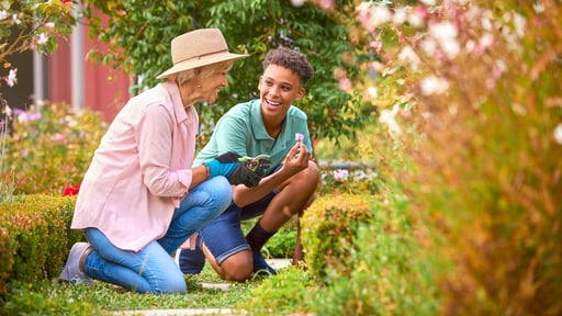 Teenage grandson and grandmother garden together