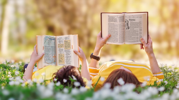 Child and adult reading Bibles from CPH together 