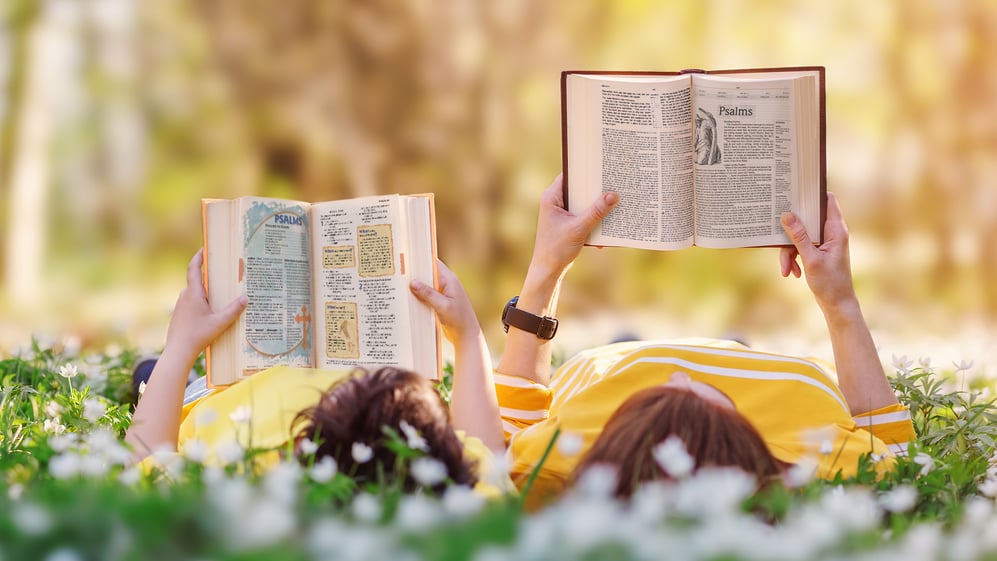 Child and adult reading Bibles from CPH together 