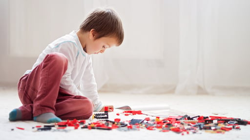 young boy building with legos