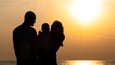 Silhouette of family at beach sunset