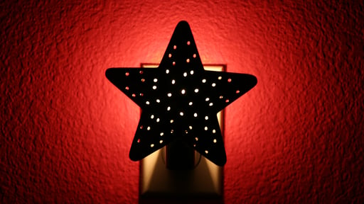 Star nightlight illuminates red wall