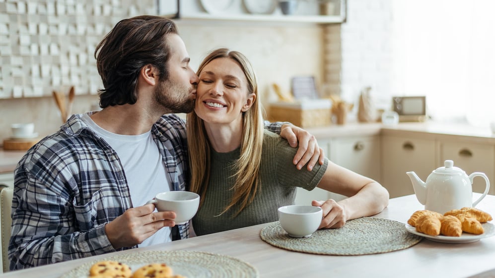 Husband and wife embrace while drinking tea