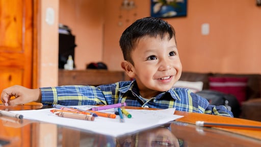 Young hispanic boy does a coloring activity