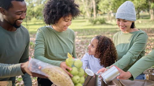 Family volunteers together packing bags of food