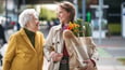 Woman helping older woman carrying groceries