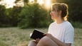 Woman reads Bible outside