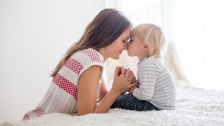 Mother prays with her toddler