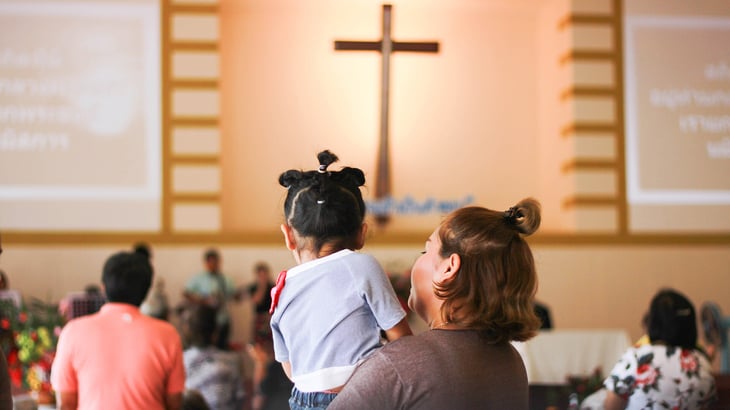 Mother holds young child at church