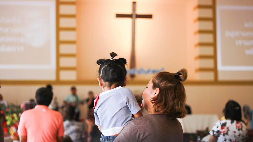 Mother holds young child at church