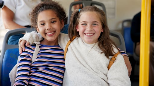 Two happy children on a school bus