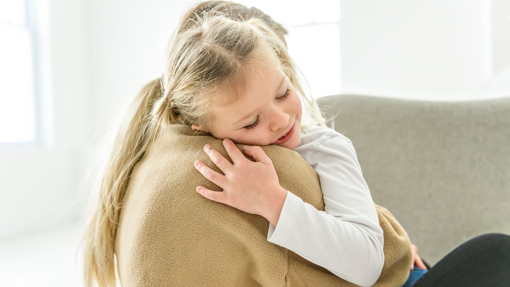Mother embraces young daughter