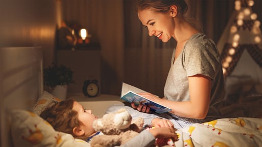 Mother reads her child Little Visits at Bedtime from Concordia Publishing House