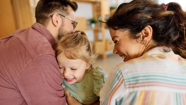 Mother, father, and child embracing